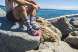 sock on a rock, wood, ocean, blue water, live model, beachfront.