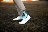 blue text, white shoes, beige pants, dead grass, water, skate socks,